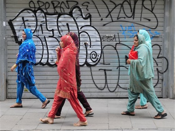 File - In this June 15, 2010 file photo women wearing veils walk in Barcelona, Spain. Spanish lawmakers will debate Tuesday July 20, 2010, barring burqas in public, joining other European countries considering similar moves on the grounds that the body-covering garments are degrading to women, the leading opposition party said Sunday. Head-covering veils would not be included in a ban. (AP Photo/Manu Fernandez, File)